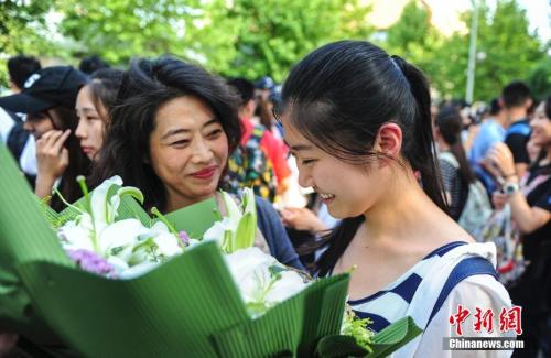 資料圖：山東濟南眾多考生手捧鮮花在家長的簇擁下歡快告別高考。中新社記者 張勇 攝