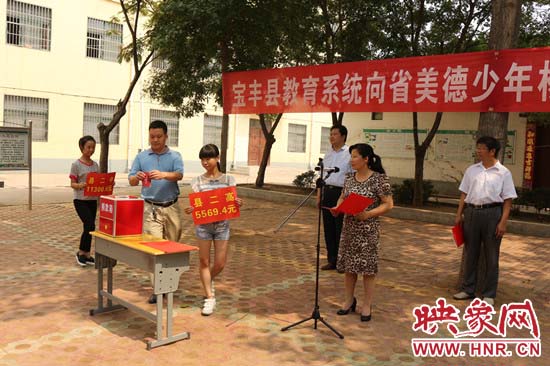 寶豐縣教育系統(tǒng)全體人員在石橋鎮(zhèn)中學(xué)為“美德少年”楊冠明同學(xué)捐款。