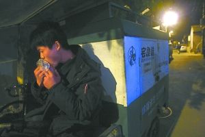 快遞哥抽空吃兩口東西。記者 李剛 攝