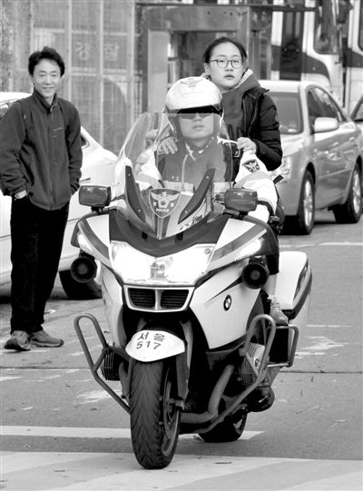 7日，首爾，警察將一名考生送抵考場。新華社發(fā)