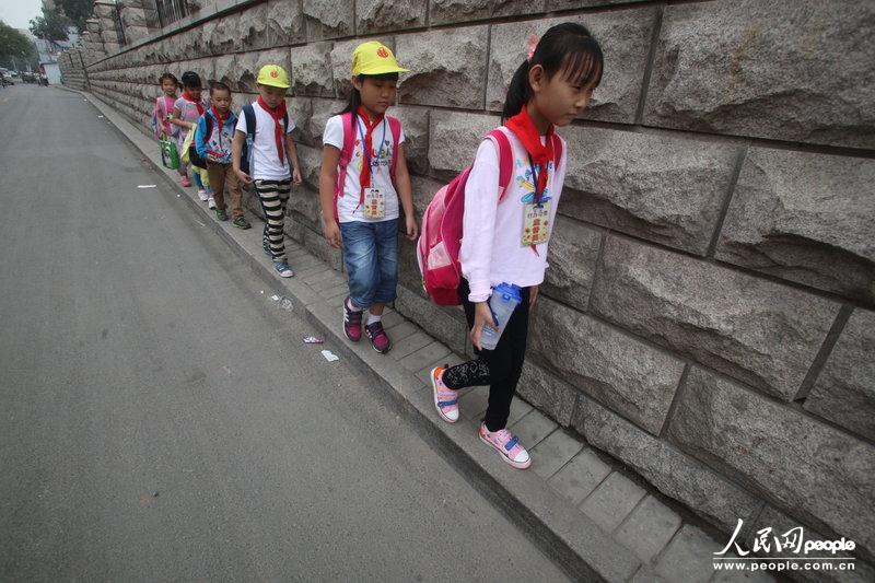 2013年09月11日，濟南運署街上，小學(xué)生走史上“最窄人行道”上學(xué)。圖片來源：CFP