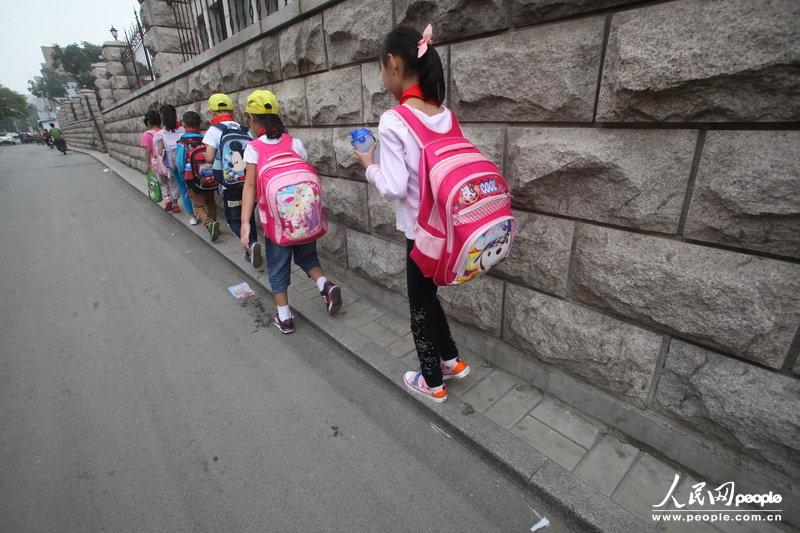 2013年09月11日，濟南運署街上，小學(xué)生走史上“最窄人行道”上學(xué)。