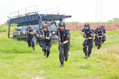 在拍攝現(xiàn)場，特警隊(duì)員下車后快速出擊。記者張琮攝影