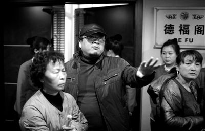 昨日，在河北香河天下第一城，相關(guān)負(fù)責(zé)人（左二）走出會議室與參加演出的老人們溝通。