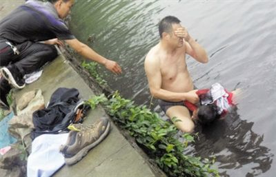 網(wǎng)友貼出民警張光聰一出河水就睜不開眼，用手抹去臉上臟水的照片。