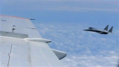 國防部網(wǎng)站12日公布的視頻截圖,日本F-15軍機從中國圖-154機頭方向危險切入,兩者最近距離約30米左右。