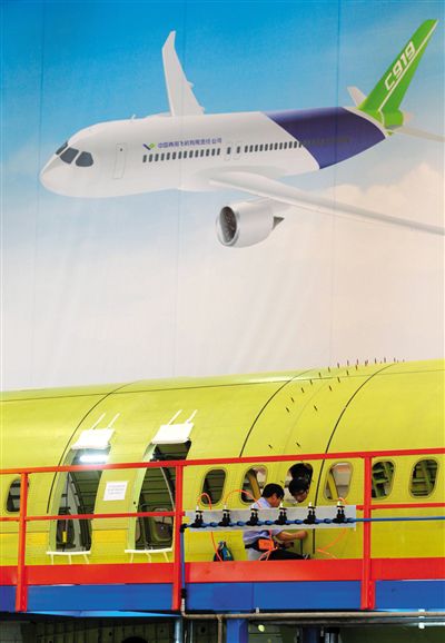 昨日，中國商飛總裝制造中心技術(shù)人員對(duì)接C919首架機(jī)的機(jī)體。新華社記者 丁汀 攝