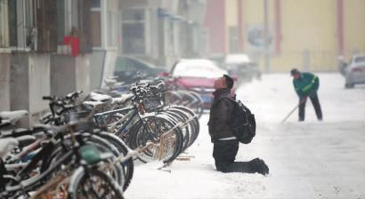 小伙子跪在樓前，一直抬頭看著樓上。 孫立國/攝