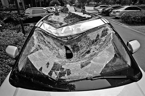 越野車車蓋以及前擋風(fēng)玻璃被砸得凹陷進(jìn)去。見習(xí)記者姚卡/攝