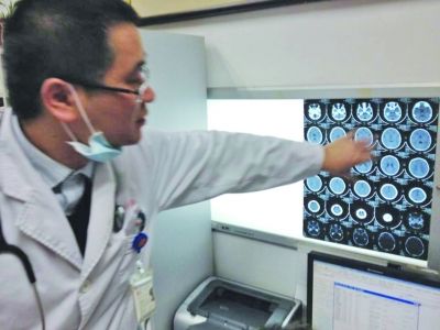 醫(yī)生在查看男孩的腦部CT片。薛馬義 攝
