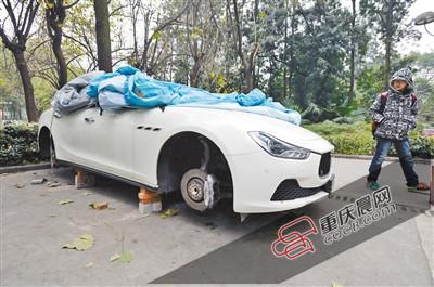 昨日，停放在重慶大學(xué)B區(qū)的一輛瑪莎拉蒂豪車被架在幾塊磚頭上，車輪不翼而飛。 重慶晨報(bào)記者 胡杰 攝