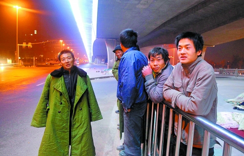 冬夜里，農(nóng)民工在橋下等著干活兒。