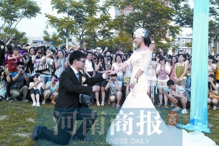 在學(xué)校操場的草坪上，兩名畢業(yè)生舉行婚禮，有同學(xué)感動地抹起眼淚
