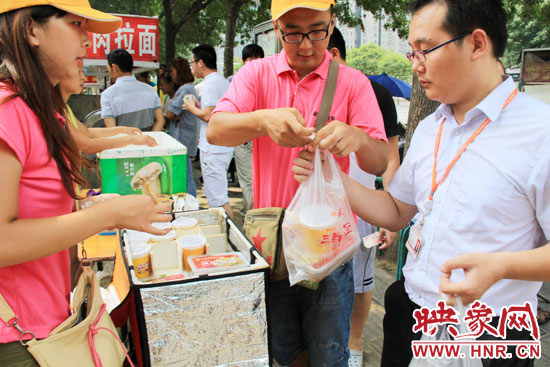 圖為徐貴雨和一名勤工助學(xué)的學(xué)生在街頭義賣快餐。