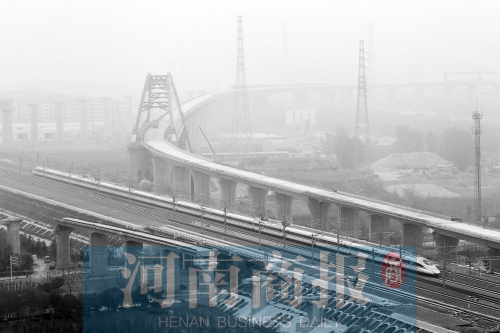 　一列高鐵從正在建設(shè)的鄭開城際鐵路旁經(jīng)過(guò)