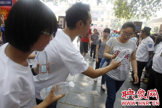 志愿者為剛剛考試完的考生送上1瓶冰凍的冰露·純悅，消暑解渴為考生加油
