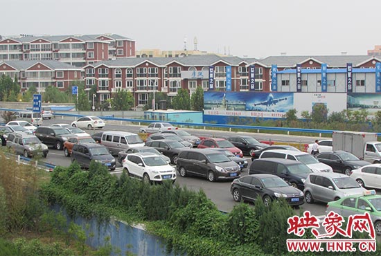 記者看到鄭州機場收費站口車輛排隊，與此形成鮮明對比的是，路的對面（另一半幅）卻車輛較少，通行順暢。