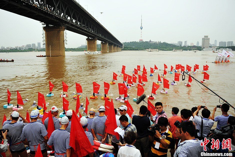 圖為江面上的橫渡方隊(duì)里的選手們劈波斬浪。中新社發(fā) 張暢 攝