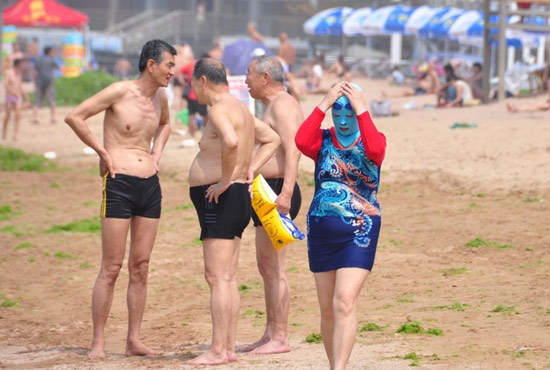 2013年7月3日，山東青島青島高溫來襲，“青島大媽”不懼滸苔，戴著“強盜面具”出現(xiàn)在海水浴場消暑降