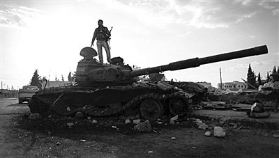 9月8日，敘利亞Zabadani，一名敘利亞反對派武裝人員站在廢棄的政府軍坦克上。