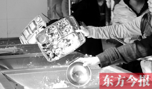 11月27日，河南中醫(yī)學(xué)院餐廳，一名同學(xué)將餐盤內(nèi)沒(méi)吃完的食物倒入餐具回收車內(nèi)
