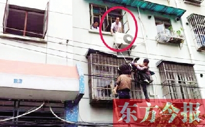施救現(xiàn)場，劉鵬（圈內(nèi)）先用繩子捆住老太確保安全 勞動(dòng)報(bào)記者 郭娜 供圖