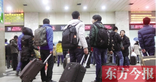 鄭州火車站東廣場(chǎng)售票大廳，幾名學(xué)生在售票窗口前躊躇