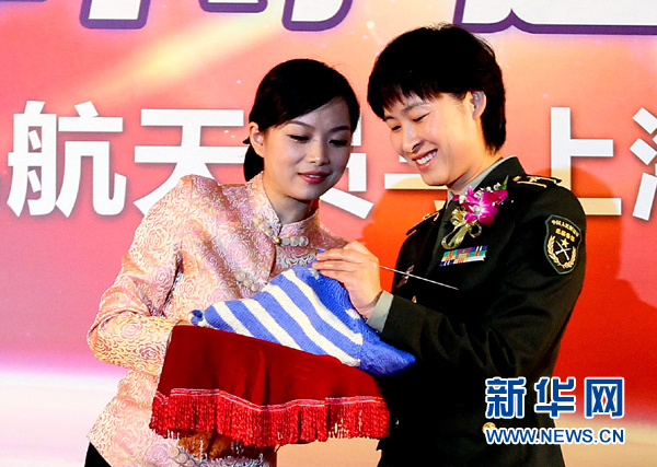 11月1日，航天員劉洋（右）在為“愛心”毛衣編織最后的收尾針。