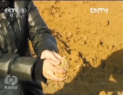 麻剛沙系麻剛石粉碎而成。記者找到一塊麻剛石，一捏就碎成粉末，硬度非常差。央視截圖