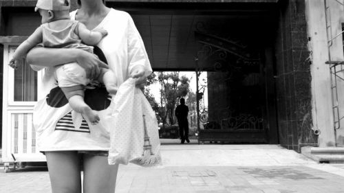 抱著孩子出售人奶的女子。