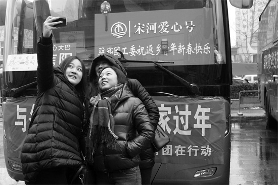 昨天上午8時(shí)，鄭州正道中環(huán)百貨廣場(chǎng)，準(zhǔn)備回家的老鄉(xiāng)在愛(ài)心大巴車前合影留念