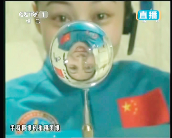 王亞平的倒影出現(xiàn)在水球中。新華社發(fā)（視頻截圖）