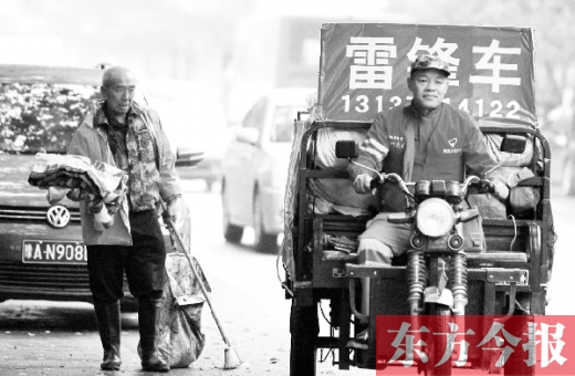 鄭州市商城路，一名環(huán)衛(wèi)工懷抱著剛剛收到的毯子，目送“雷鋒哥”孫德坤離開