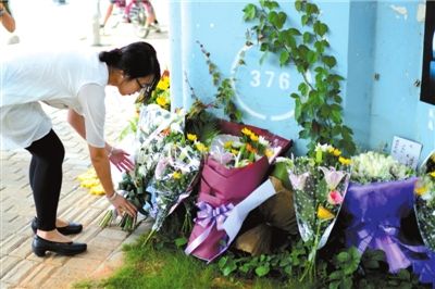 6月8日下午，記者來到廈門公交車爆炸事發(fā)現(xiàn)場橋下，附近已聚集了十幾個自發(fā)前來悼念的市民。橋墩下排放了一圈或黃或白的菊花，還有玖瑰、百合等。