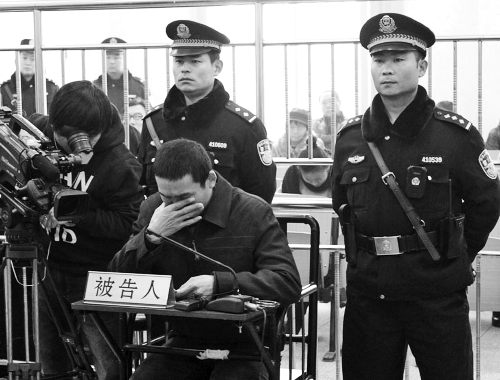 庭審中,29歲的李軍低著頭。