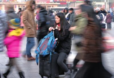 春運(yùn)首日，北京站客流量明顯增多，一名女孩在人流中等待進(jìn)站。