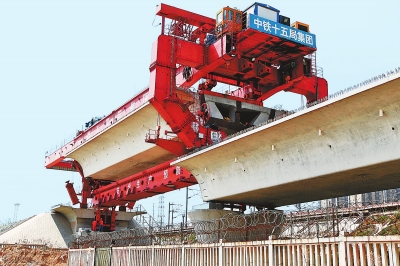 建設(shè)者們操縱巨型起重機(jī)在吊放橋墩。記者鄧放攝