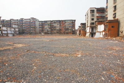 為降塵，旮旯王村拆遷后裸露的地面上鋪了一層石子。