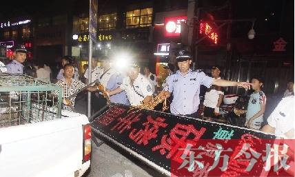 7月8日晚，鄭州市商城路一家占道經(jīng)營的攤販招牌被執(zhí)法隊(duì)員“登記保存”