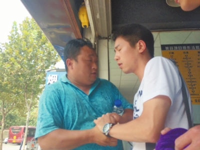 記者正查看照片，突遭藍(lán)衣男強(qiáng)搶手機(jī)。