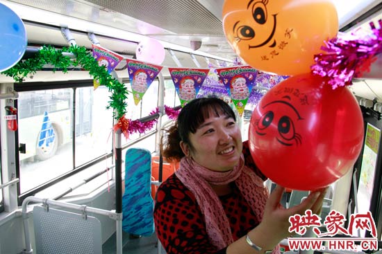 鄭州快速公交B3區(qū)間線車長李鵬云在車廂里懸掛氣球，布置圣誕車廂，營造歡樂圣誕氛圍