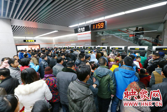 地鐵開通首日，上午十一點五十九分，紫荊山地鐵站售票機前擠滿了買票的市民。
