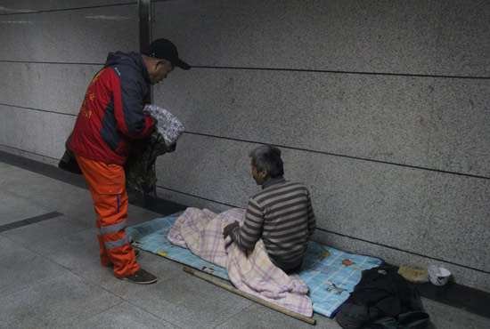 在鄭州一處地下通道，孫德坤挑了幾件衣服送給了流浪者