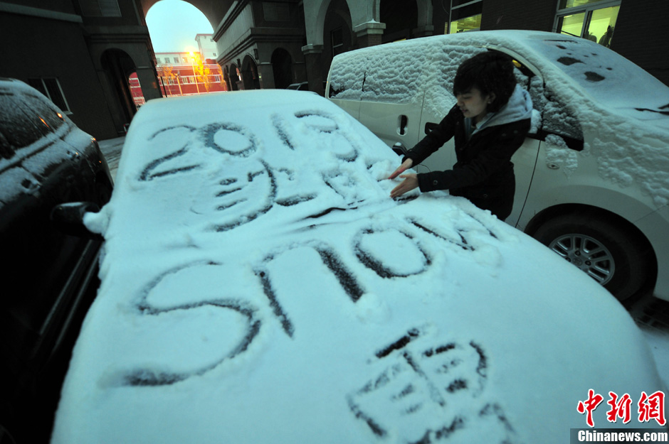 11月18日，行人在車輛的積雪上涂鴉。
