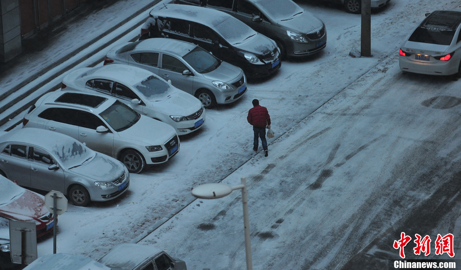 11月18日，行人在沈陽街頭的積雪中穿行。
