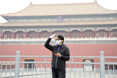 11月1日，北京大部分地區(qū)重度污染，一名游客戴著口罩在午門前揮手跟朋友打招呼。 實(shí)習(xí)生 王飛 攝