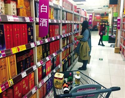 顧客在商場(chǎng)的高檔白酒貨架前駐足挑選。春節(jié)臨近，受“禁令”影響，以高檔白酒為代表的節(jié)日禮品市場(chǎng)面臨考驗(yàn)。記者 王遠(yuǎn)征 攝