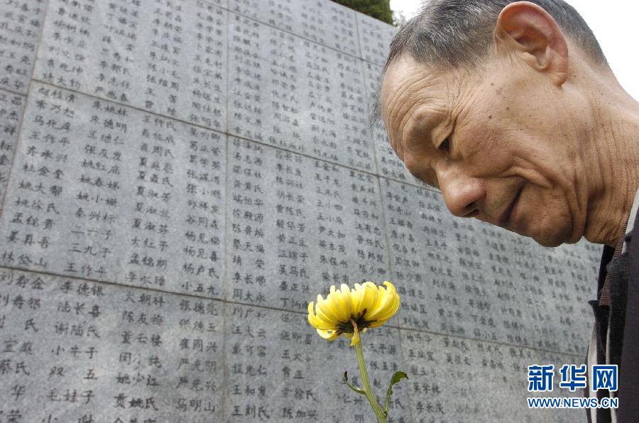 2006年4月5日，74歲的南京大屠殺幸存者佘子清手捧鮮花，祭奠被日軍殺害的母親。