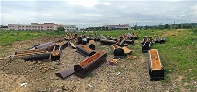 40多副棺木被砸壞后，扔在荒地上。