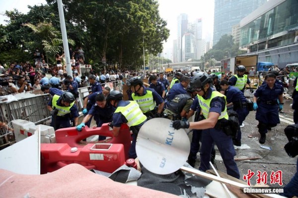 10月14日，警方清除金鐘道障礙物。大批警員在金鐘道現(xiàn)場清拆障礙物。部分警員戴上頭盔將障礙物移走。